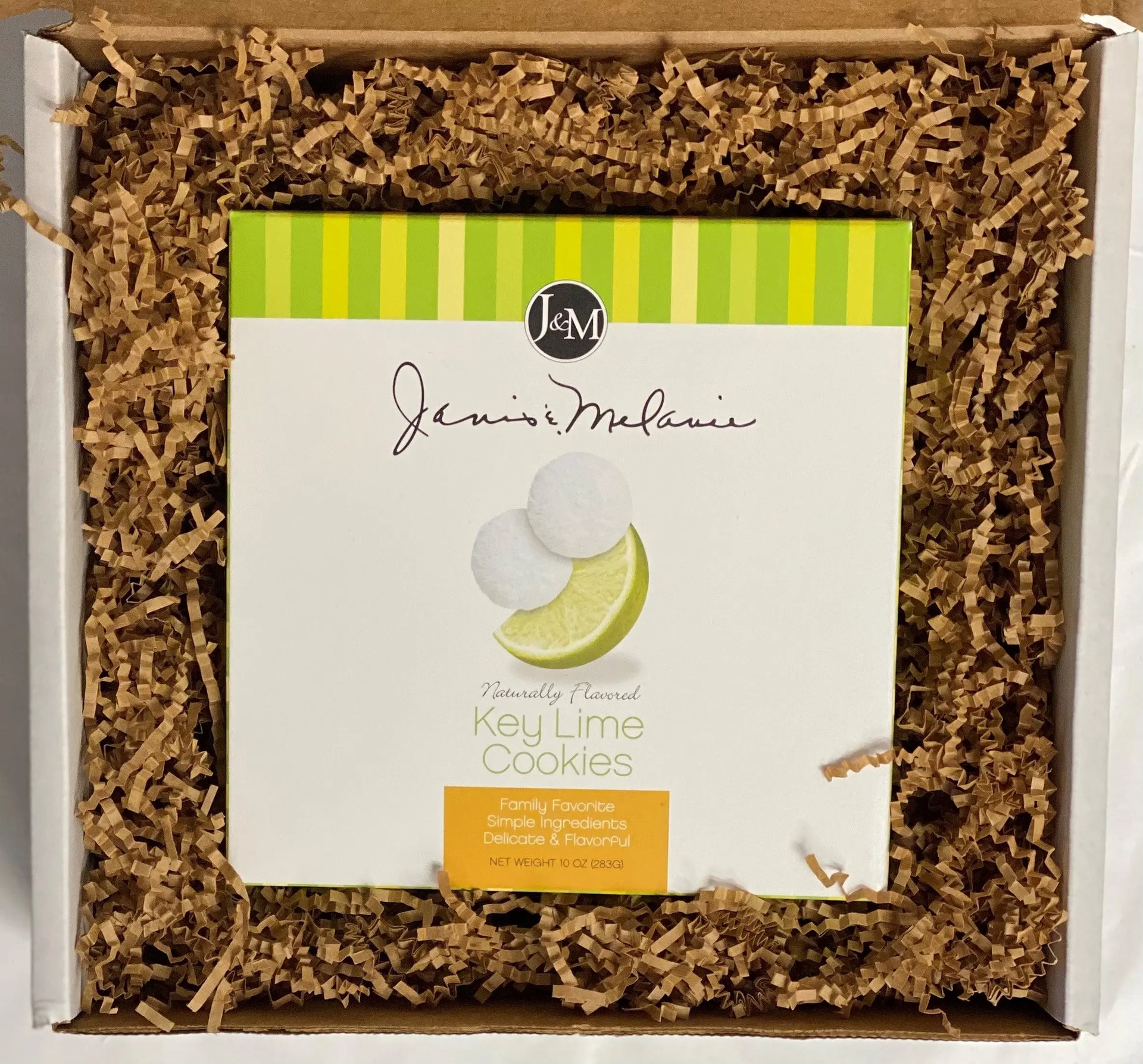 A small Food=Love box with a 10oz box of Janis and Melanie Key Lime Tea Cookies, cushioned with kraft krinkle paper packaging.